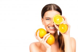 オレンジを持つ笑顔の女性